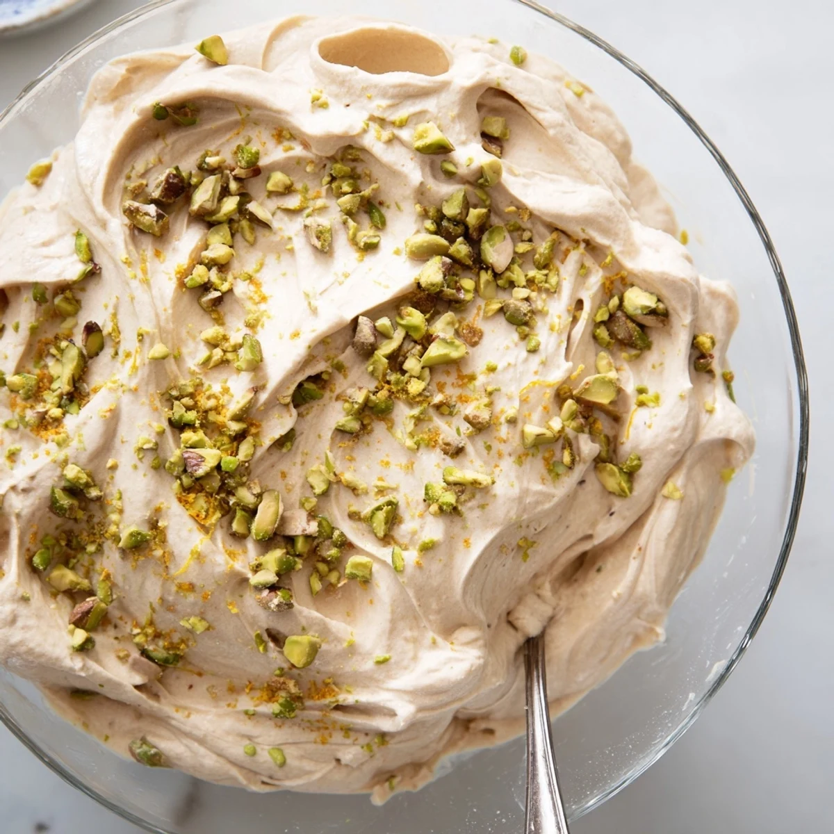 Creamy Lebanese date orange blossom mousse topped with chopped pistachios and fresh orange zest