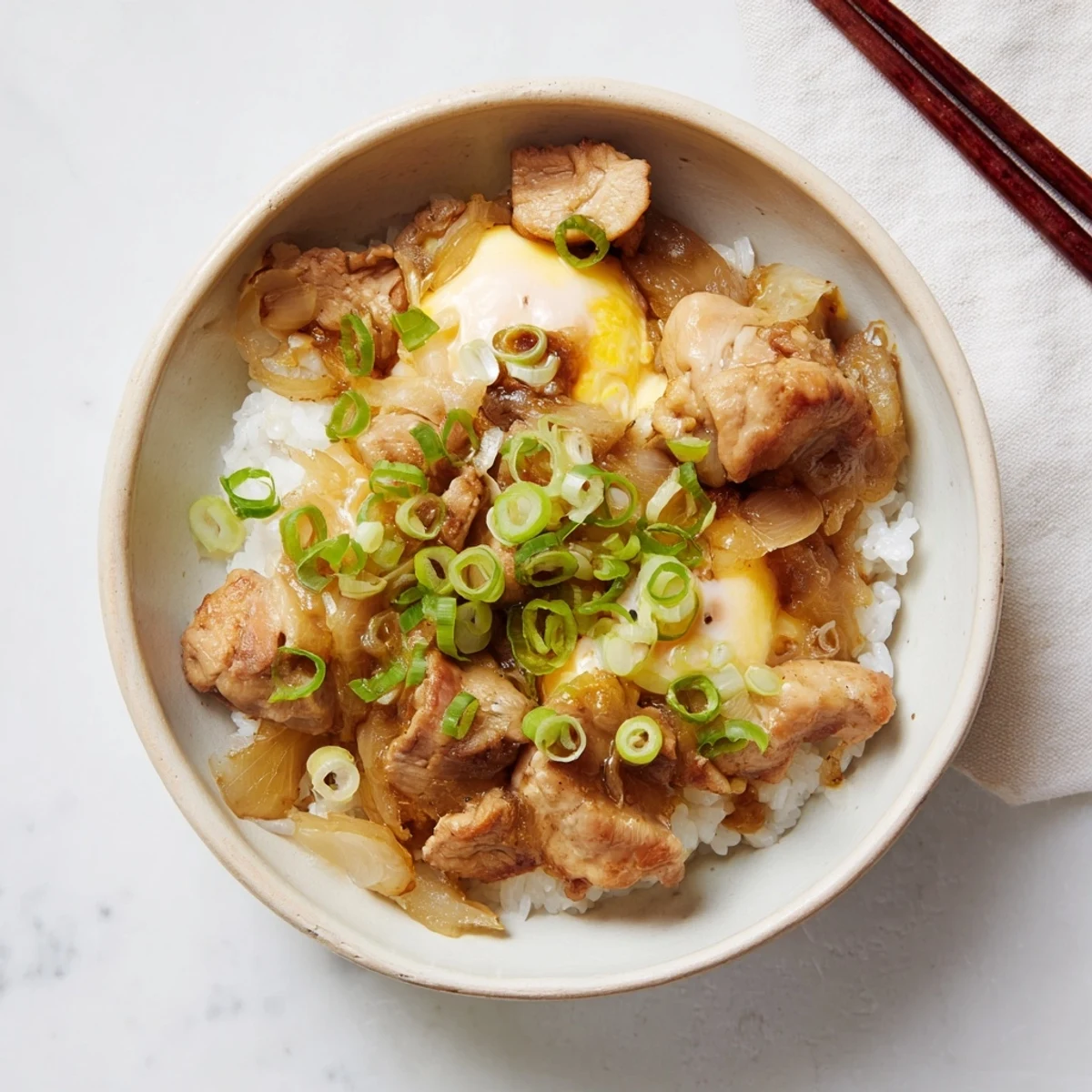 Japanese Oyakodon featuring savory chicken and onion in golden egg over white rice