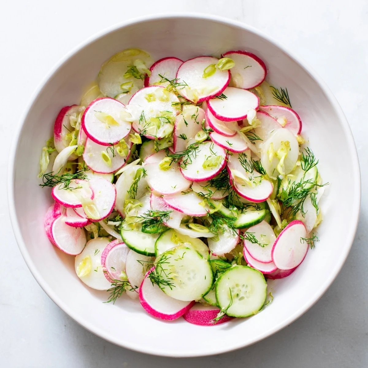 Colorful radish and cucumber salad with green onions and fresh herbs ready for a light summer meal