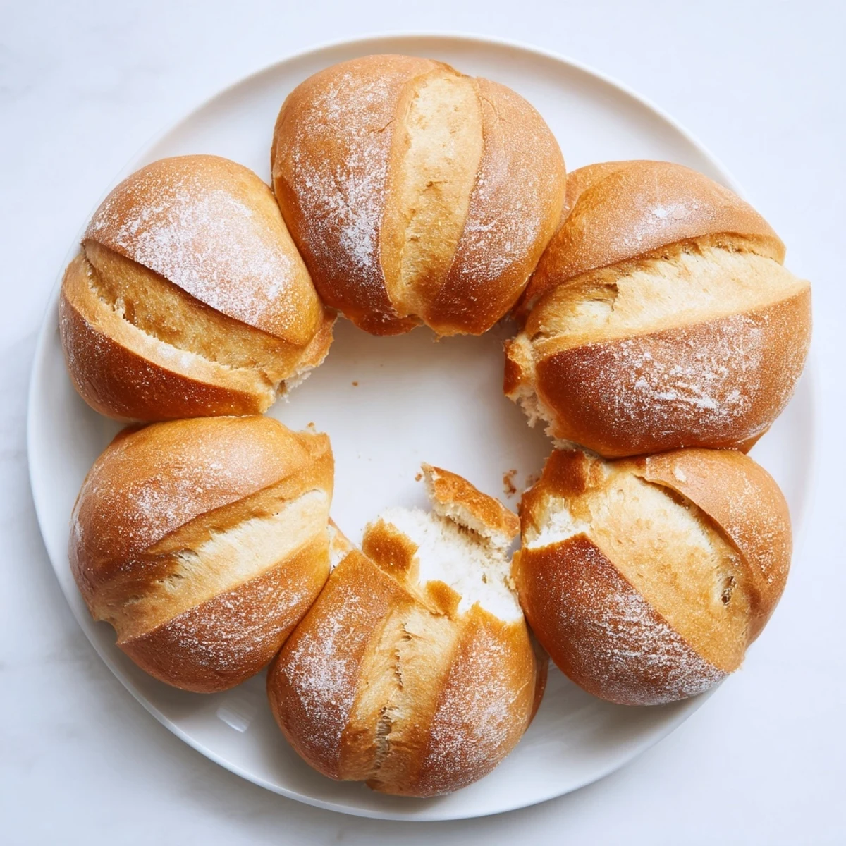 Golden crusty French bread rolls fresh from the oven with flour-dusted tops