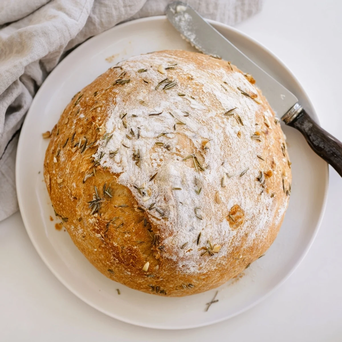 Rustic homemade loaf baked in cast iron with aromatic minced garlic and rosemary