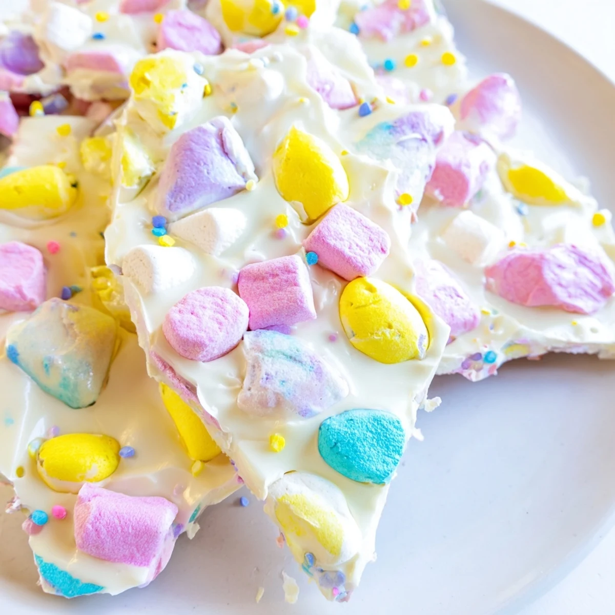 Homemade Easter marshmallow bark displaying swirled melted white chocolate with vibrant pastel marshmallows