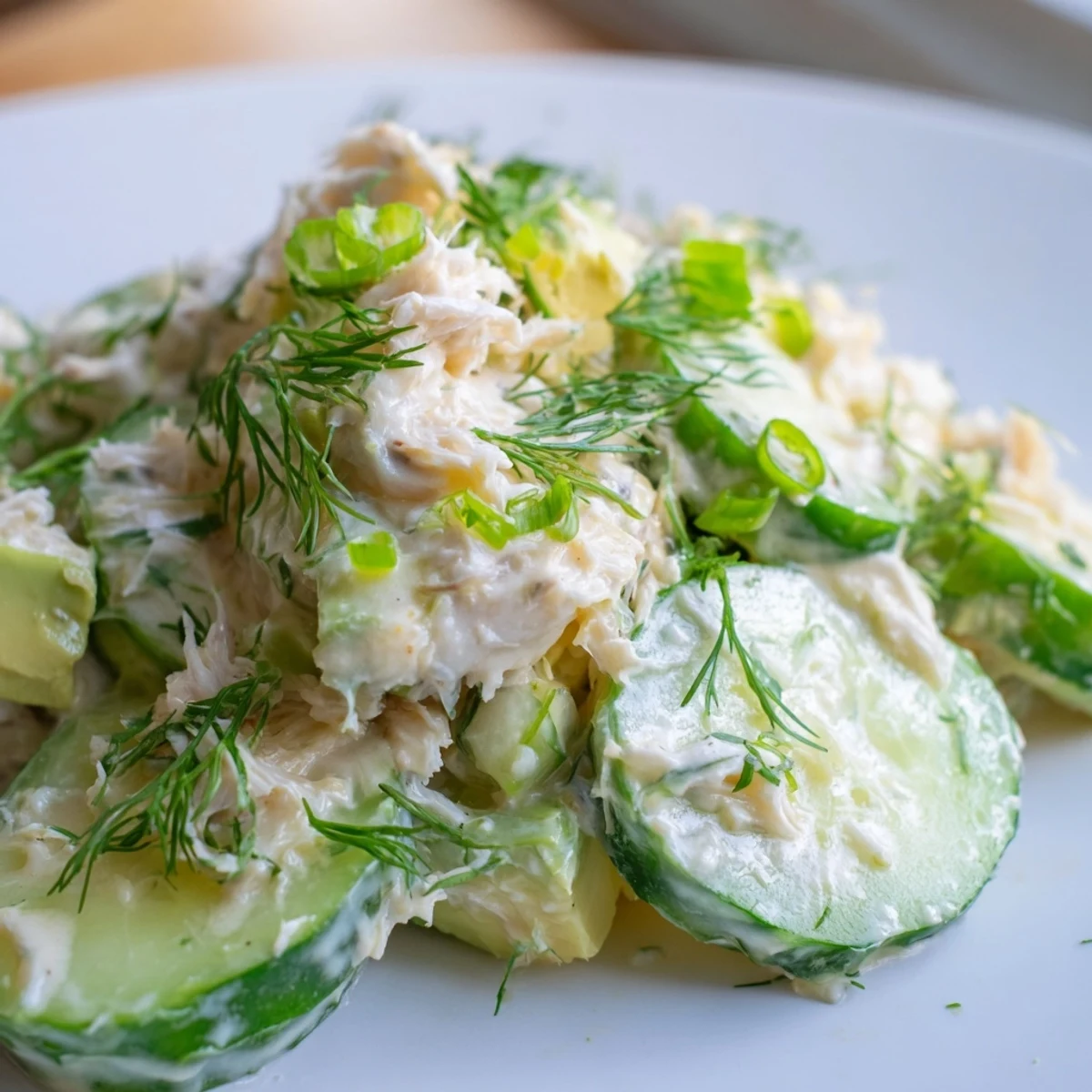 Chilled cucumber salad with crab meat and avocado served beside bright lemon wedges