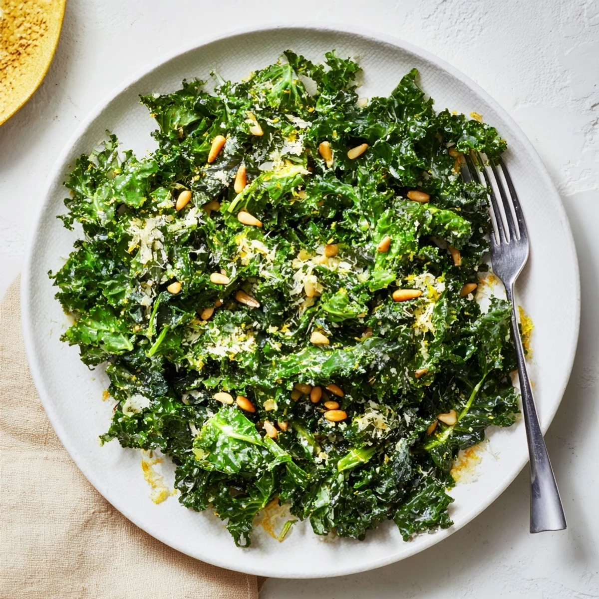 Fresh garlic lemon Parmesan kale salad in a wooden bowl with shaved cheese