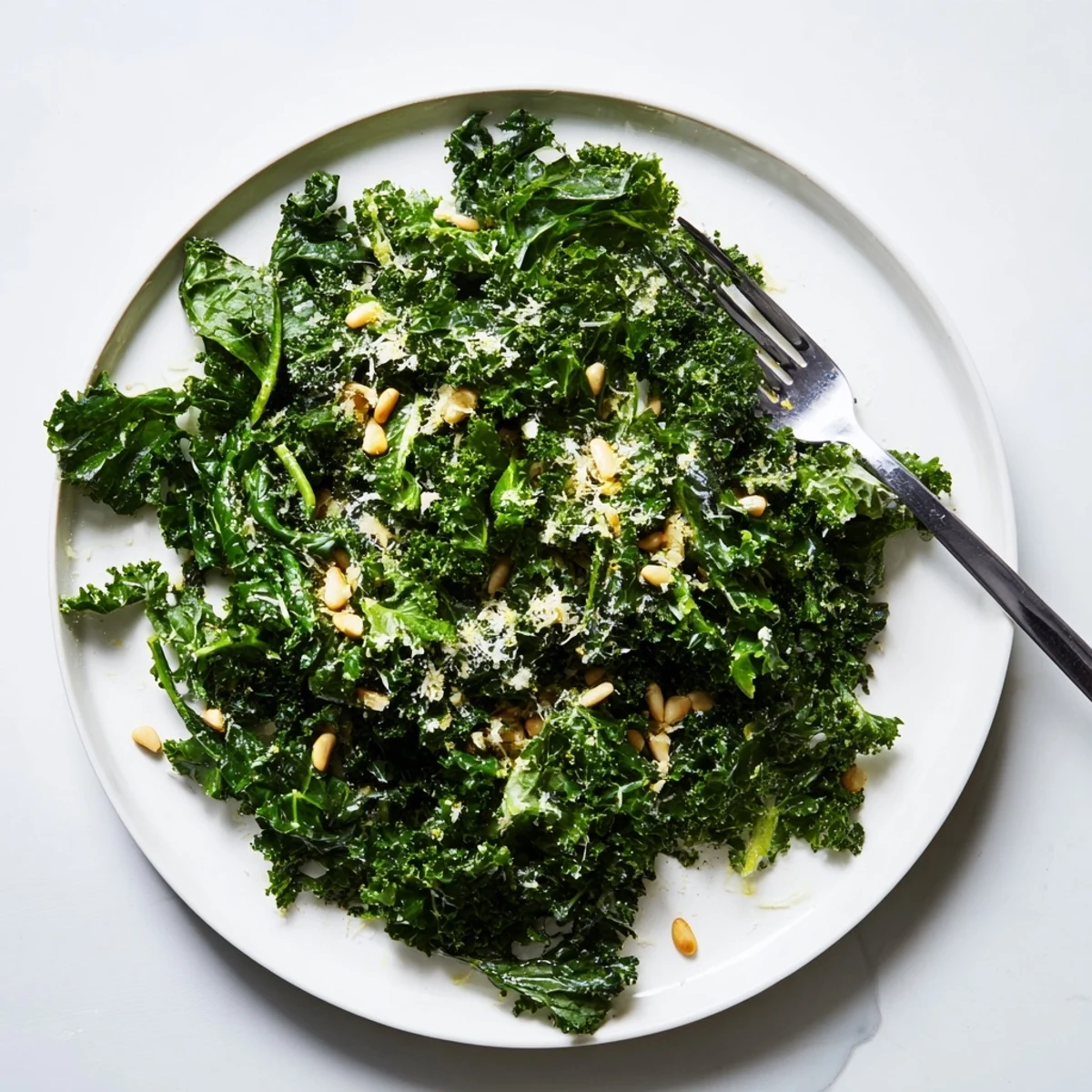 Bright green kale leaves massaged with zesty garlic lemon Parmesan dressing coating each piece