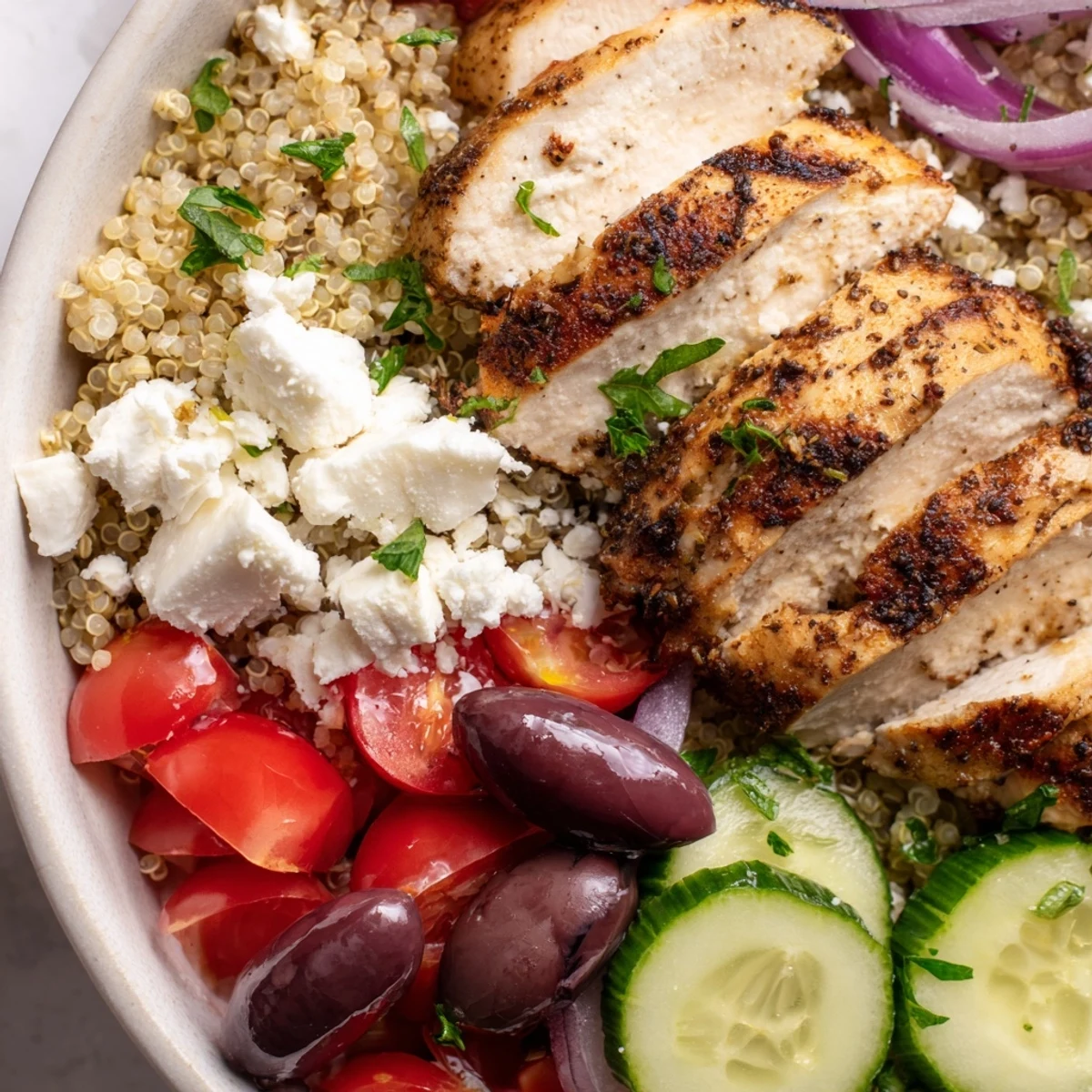 Fluffy quinoa and tender sliced chicken star in this vibrant Mediterranean chicken quinoa bowl