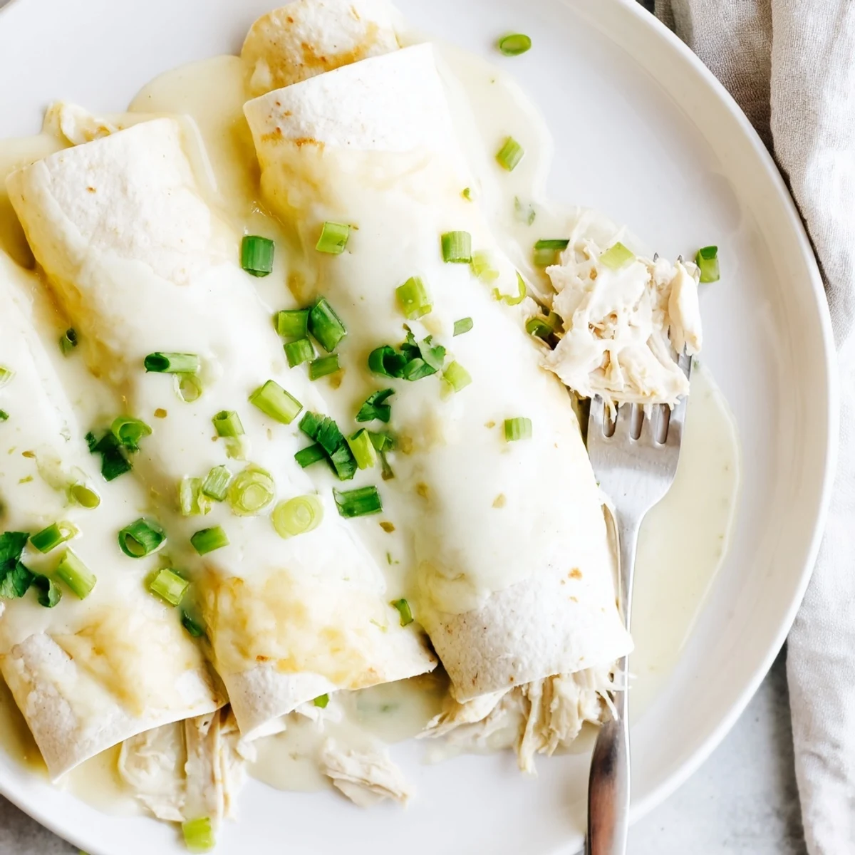Warm Creamy White Chicken Enchiladas on plate, velvety sauce, tender shredded chicken