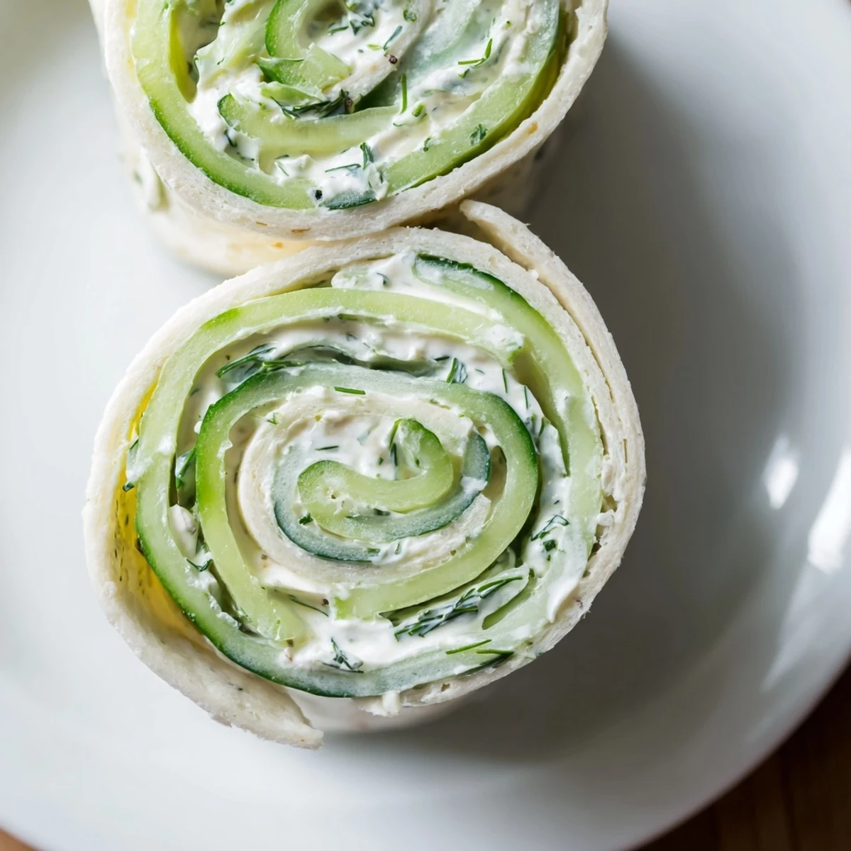 Cucumber And Dill Pinwheels arranged on platter, chilled, creamy dill filling visible