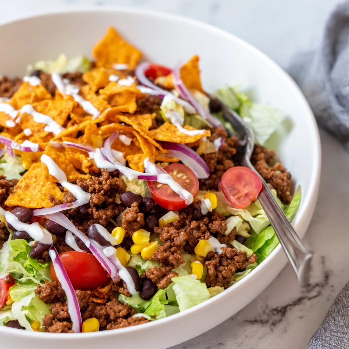 Family style Simple Doritos Taco Salad tossed with cheddar, black beans, fresh tomatoes.