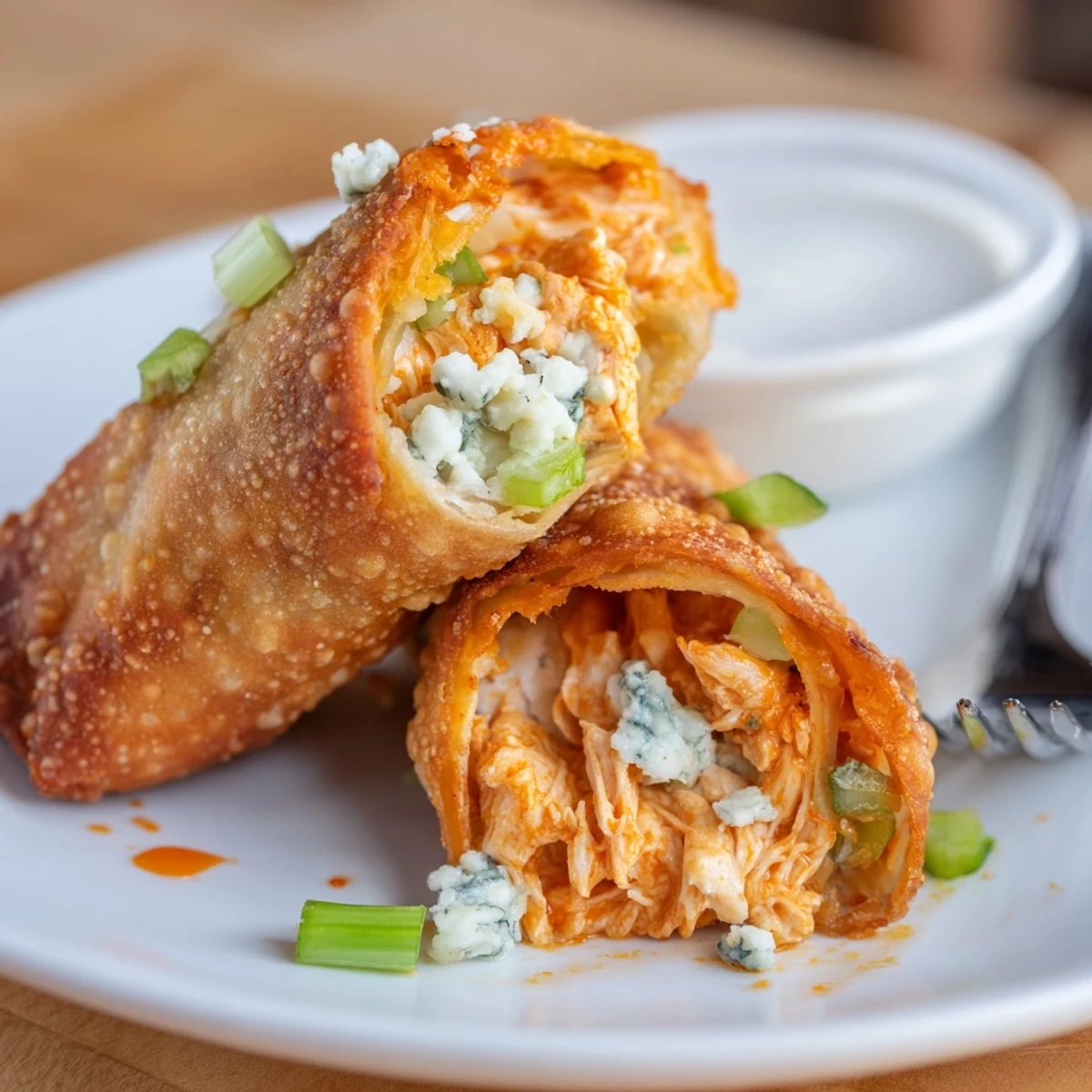 Crispy Buffalo Chicken Egg Rolls Recipe piled on platter with ranch dip