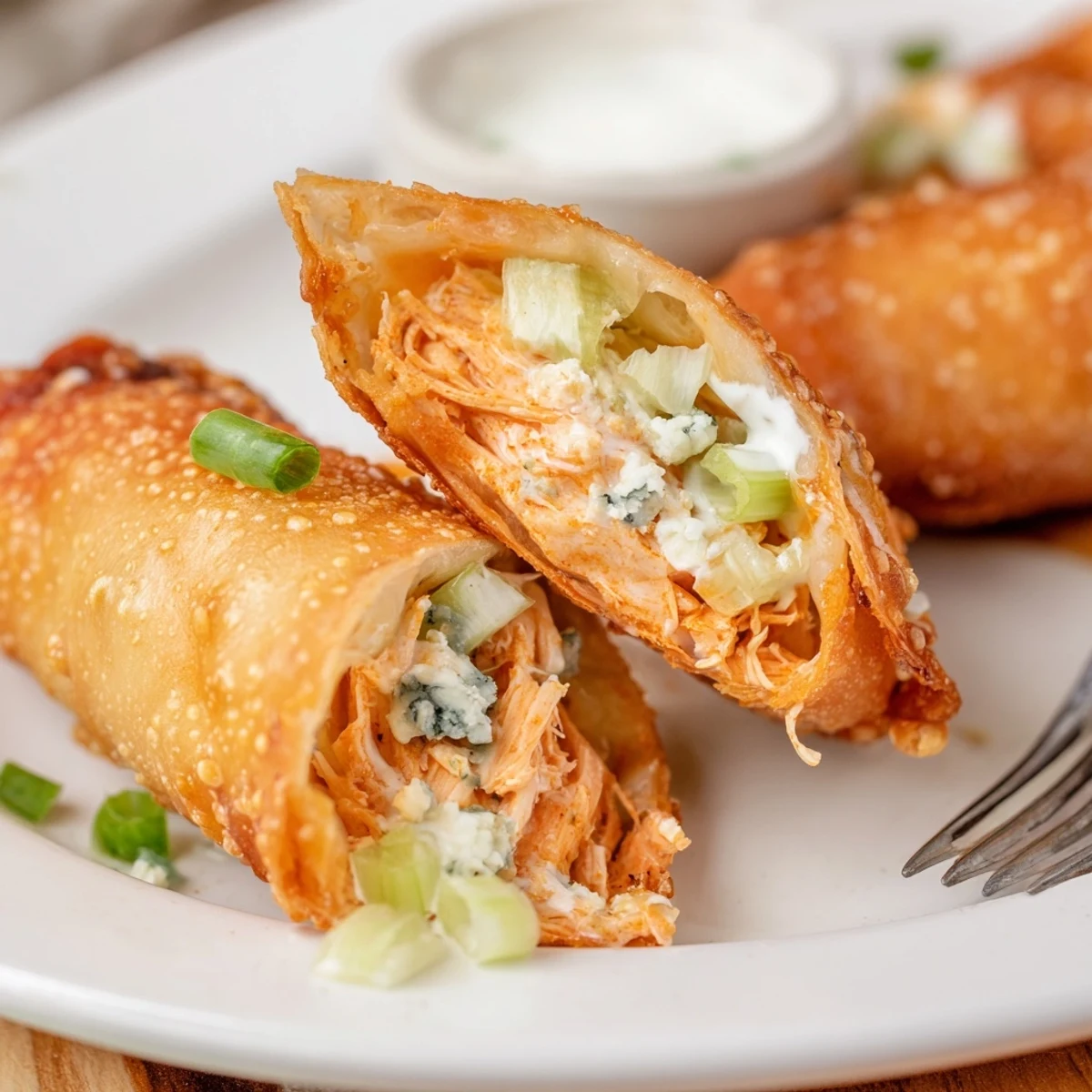 Golden fried Buffalo Chicken Egg Rolls Recipe oozing cheesy filling, celery crunch