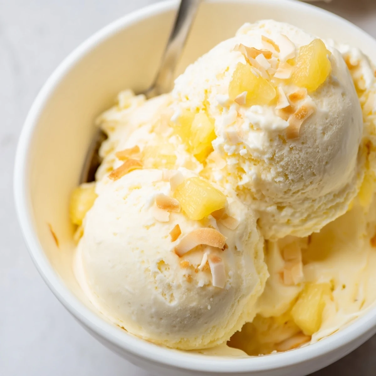 Churned Creamy Pineapple Ice Cream chilled to silky perfection, garnished with mint