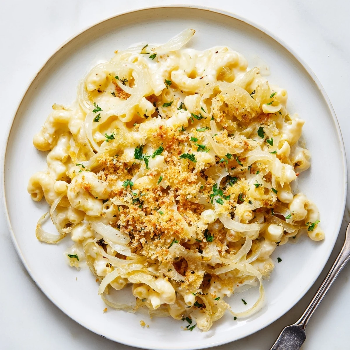 Creamy French onion mac and cheese topped with golden caramelized onions and crispy melted breadcrumbs