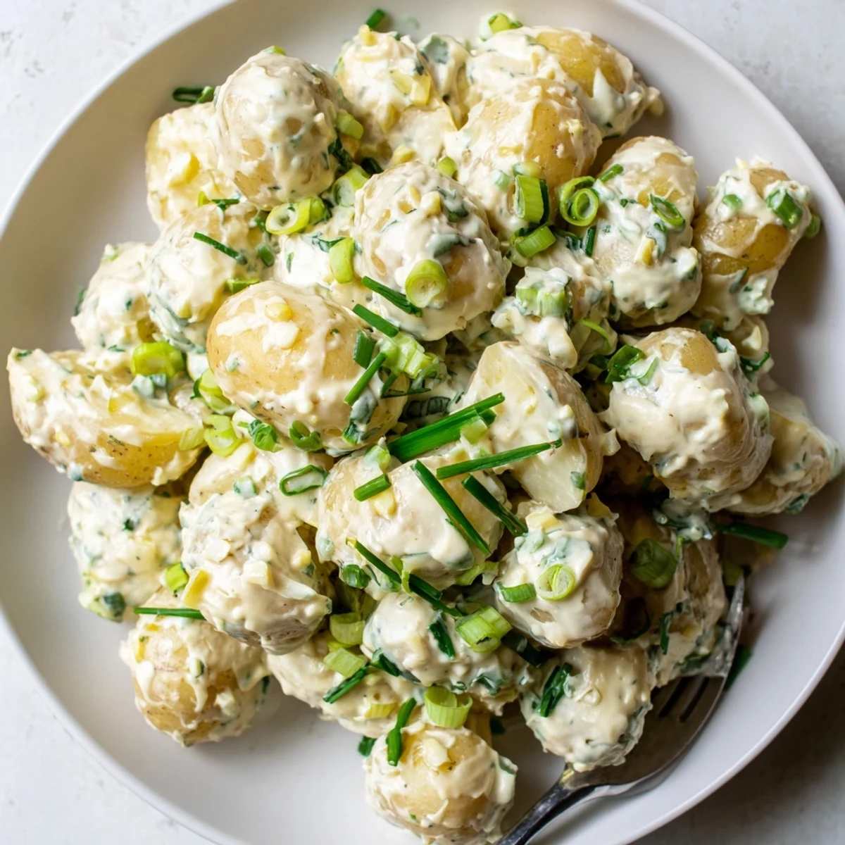 Sour Cream And Onion Potato Salad with chives, scallions, picnic-ready.