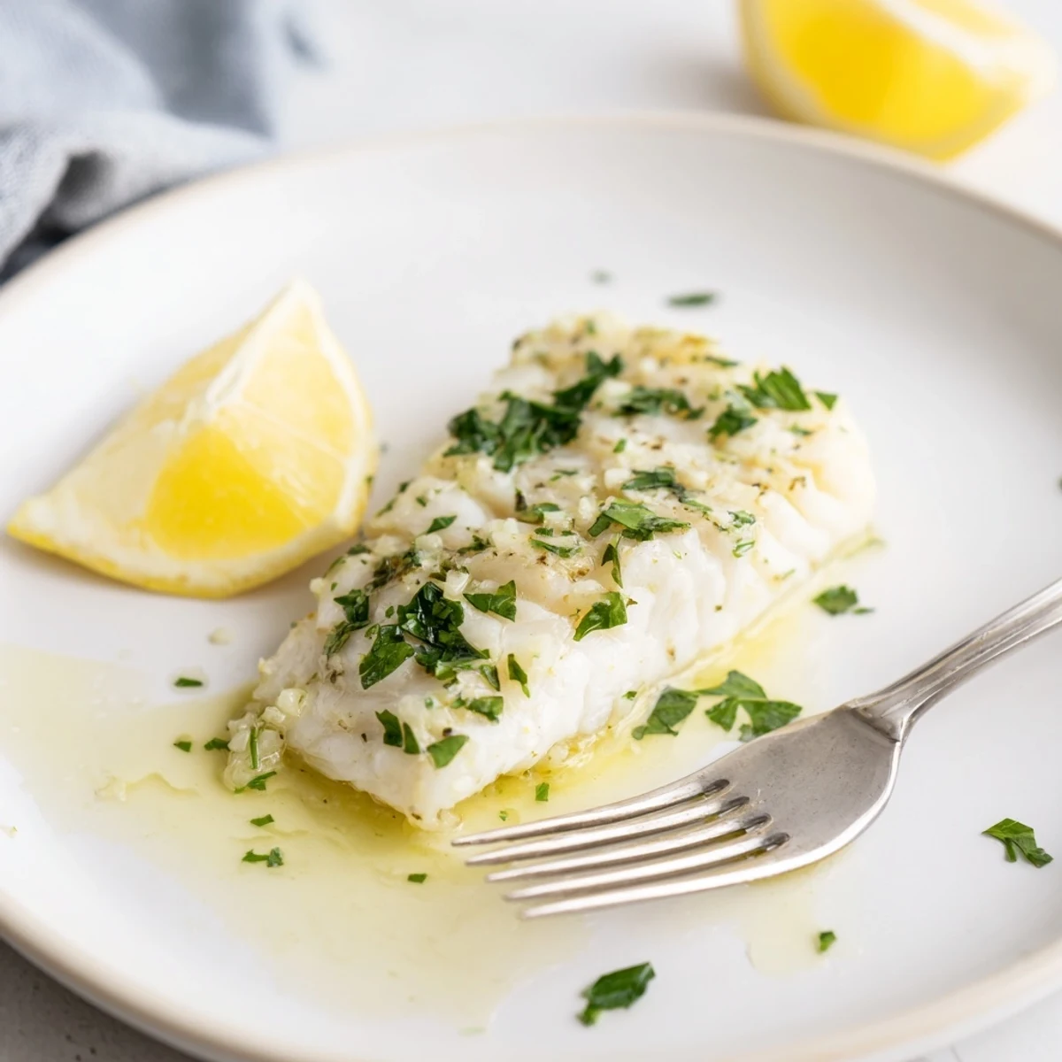 Pan-ready Garlic Butter Fish Recipe topped with fresh parsley and lemon wedges