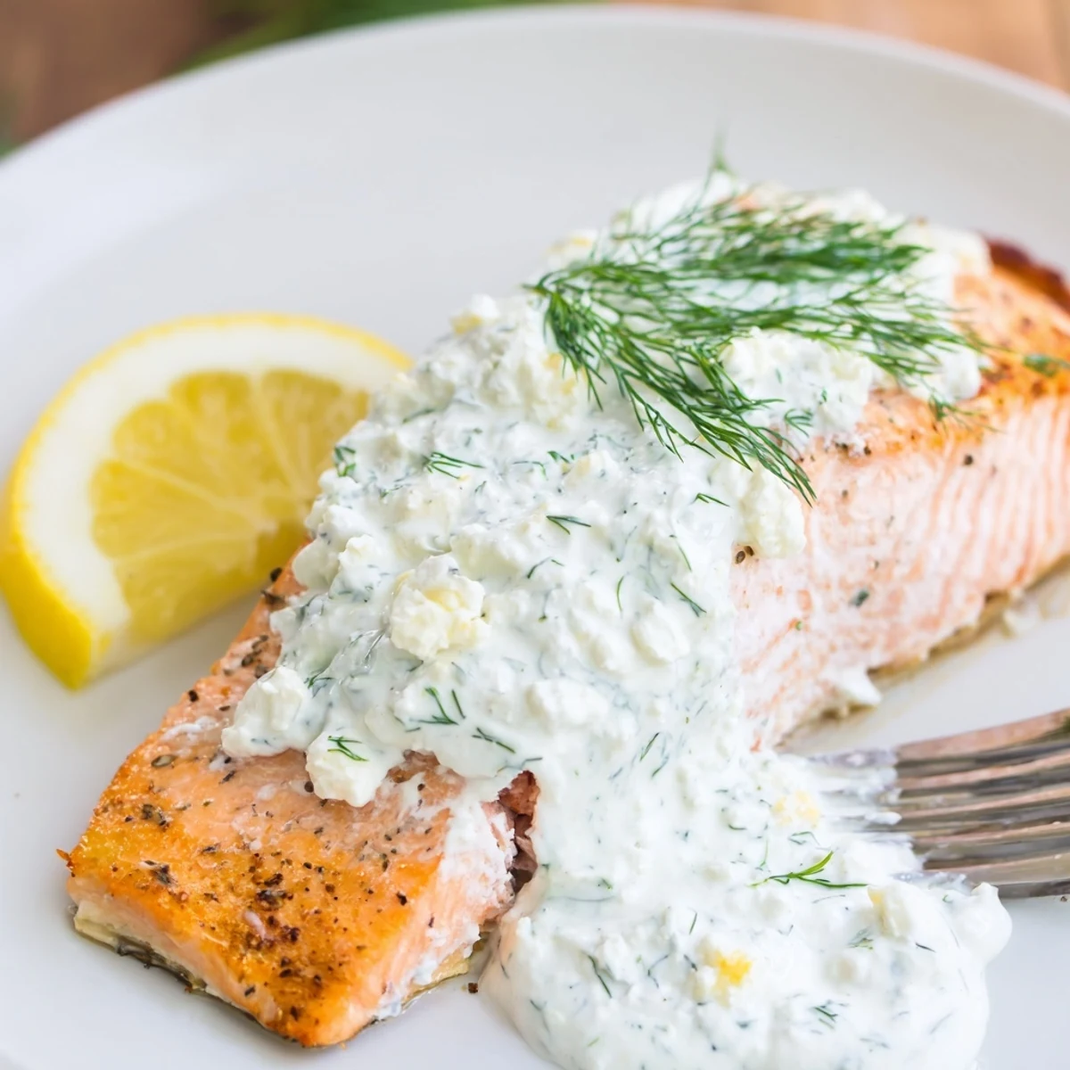 Oven roasted Salmon With Feta Dill Sauce, flaky fillets garnished with dill.