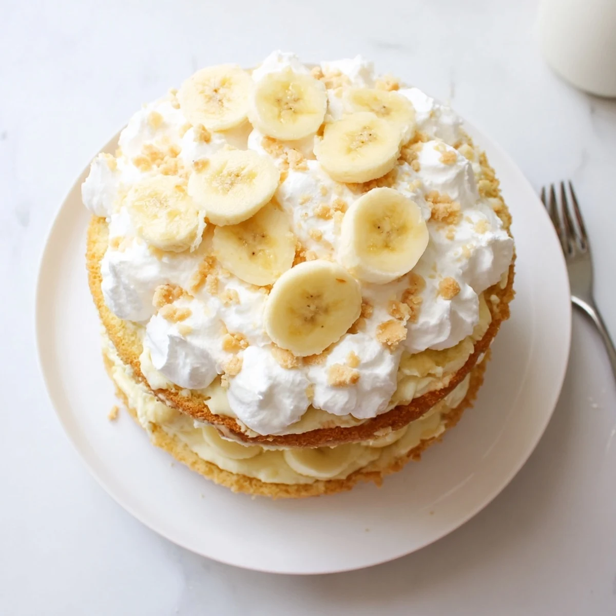 Southern-style banana pudding cake featuring moist layers filled with creamy vanilla pudding and crushed cookies