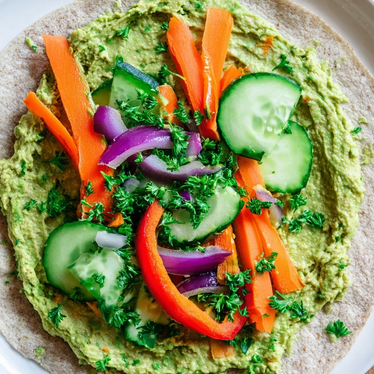Golden whole wheat tortilla rolled with vibrant green spinach hummus and colorful crisp vegetables