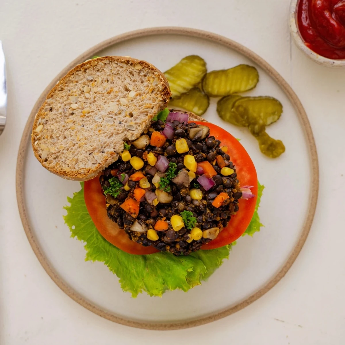 Homemade veggie burgers recipe plated with crispy pickles and onion on a wooden board