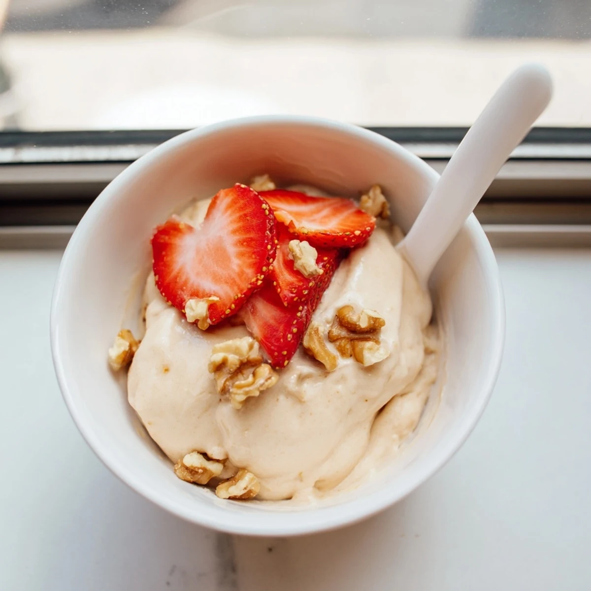 Vegan healthy nice cream scooped into glass bowls featuring colorful fruit toppings