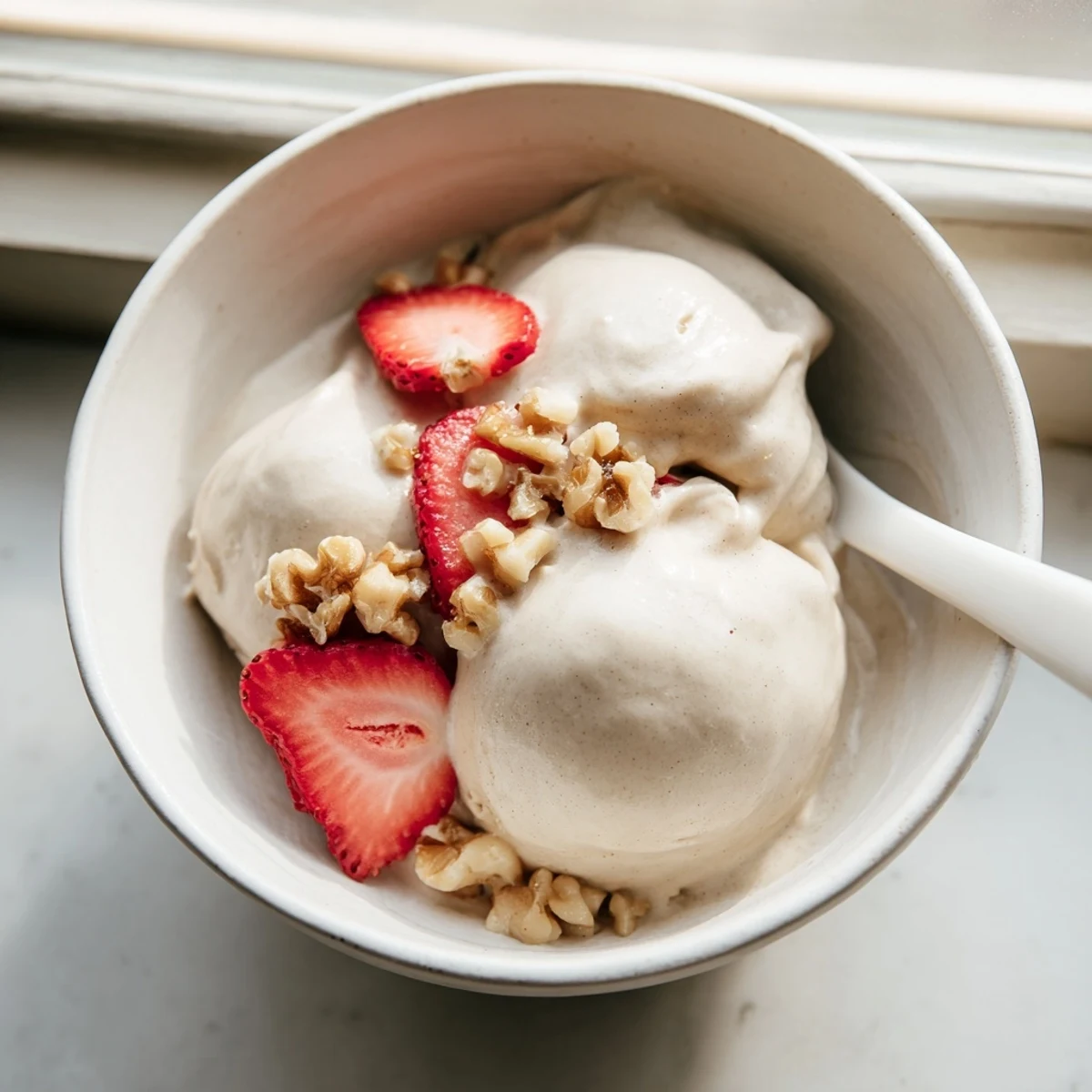 Dairy-free healthy nice cream recipe with swirls of chocolate and sliced banana garnish