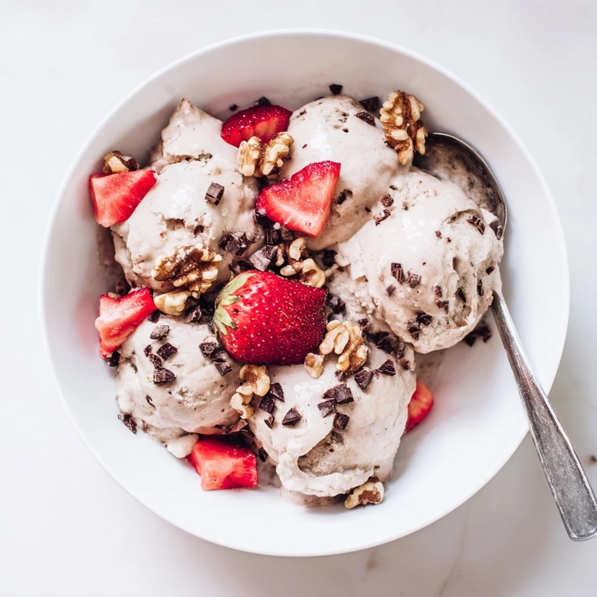 Dairy-free banana nice cream recipe showing smooth soft-serve texture scooped into a decorative glass