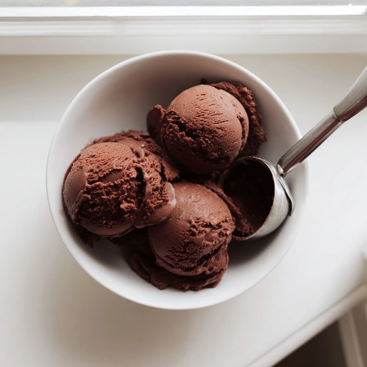 Creamy chocolate sourdough ice cream scooped into a chilled bowl with dark chocolate shavings