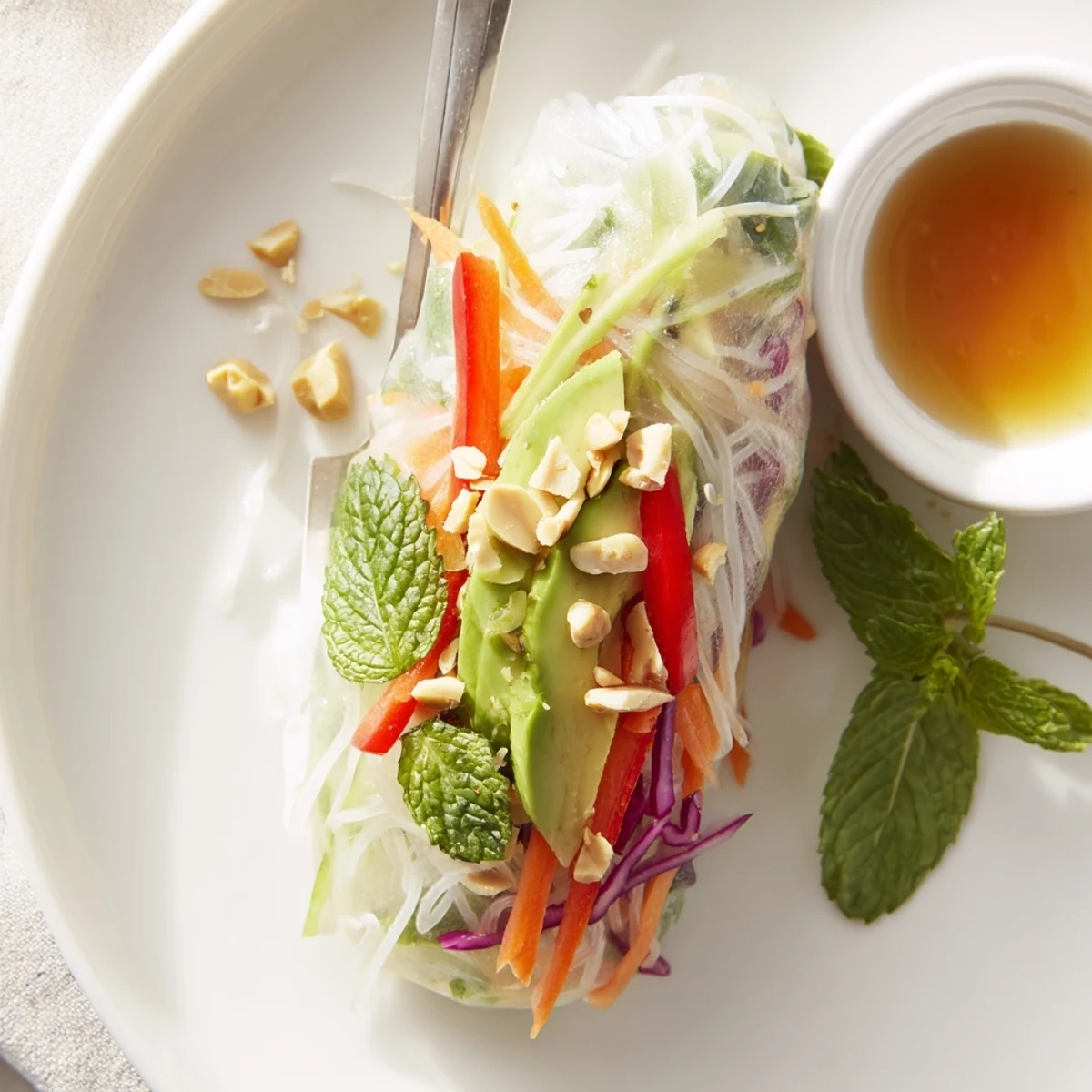 Fresh Gluten Free Vegetable Spring Rolls served with tangy dipping sauce and sliced avocado
