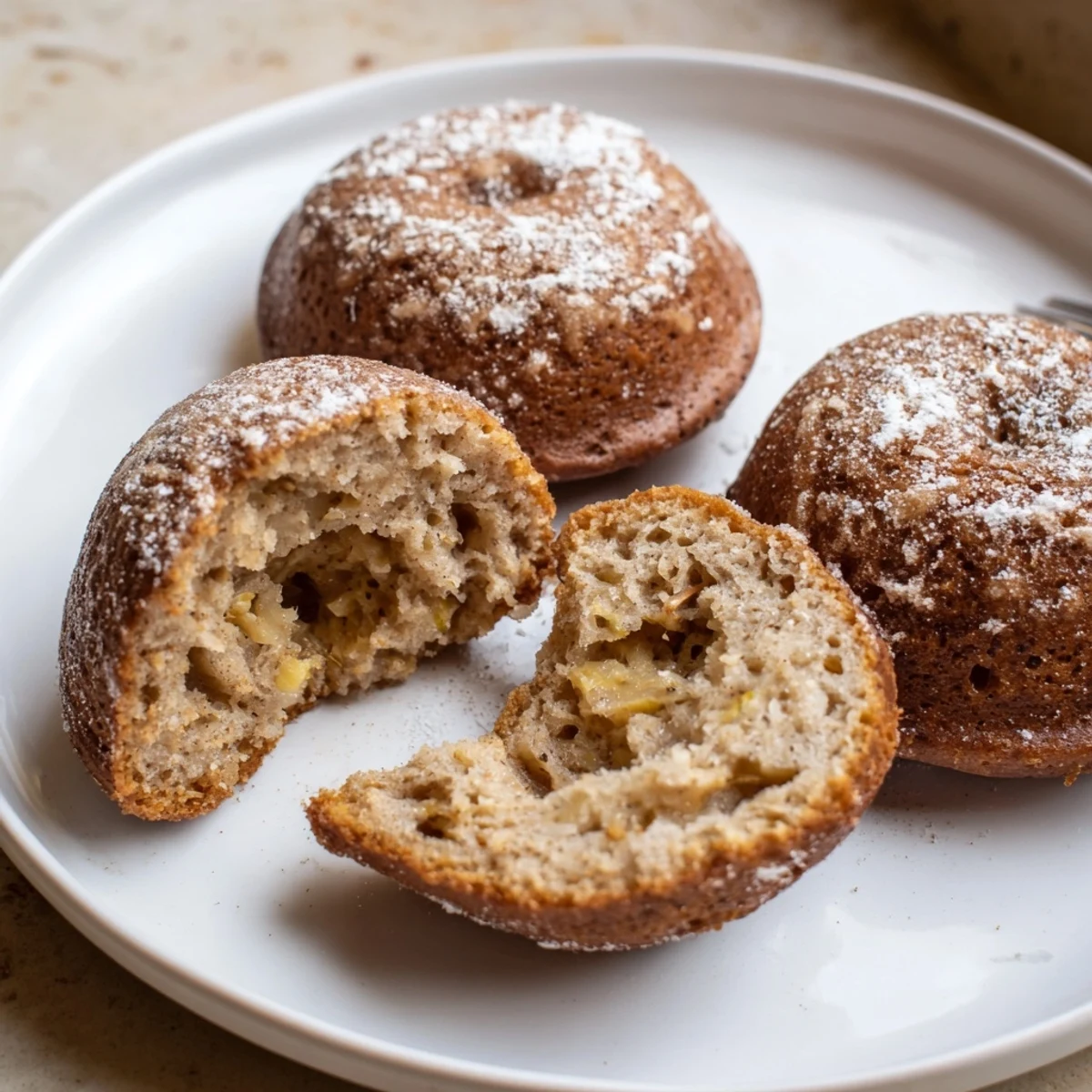 Plate of glazed Banana Donuts beside morning coffee, golden edges visible