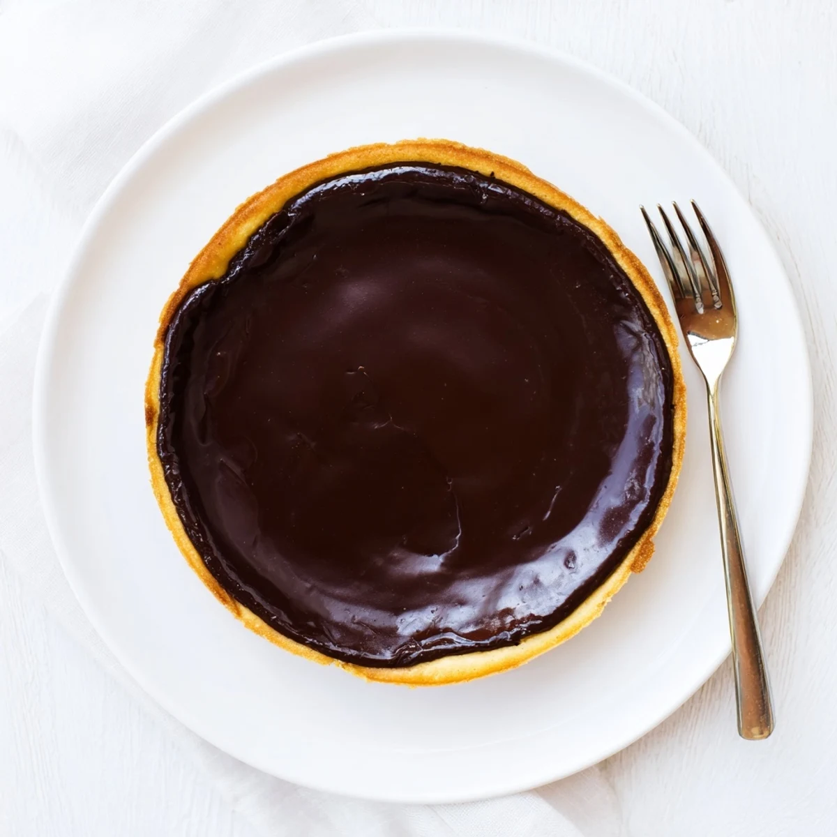 Rich French chocolate flan with silky smooth custard filling in golden buttery tart crust