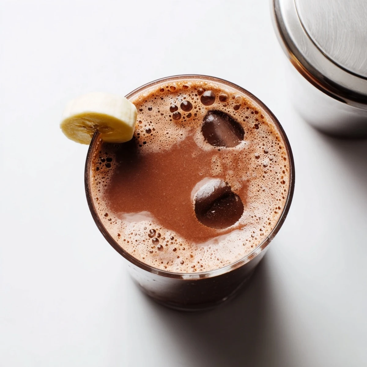 Creamy post-workout smoothie blending frozen banana cocoa powder and protein powder in a blender