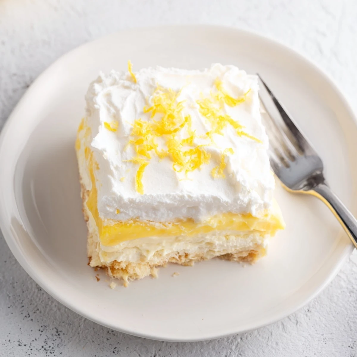 Fresh lemon lush cake with fluffy white topping and vibrant citrus zest garnish
