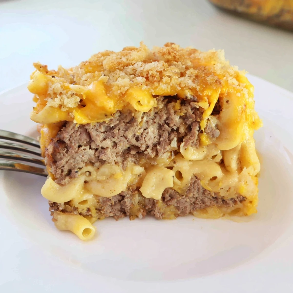 Golden baked mac and cheese meatloaf casserole with bubbling cheesy topping and crispy breadcrumbs