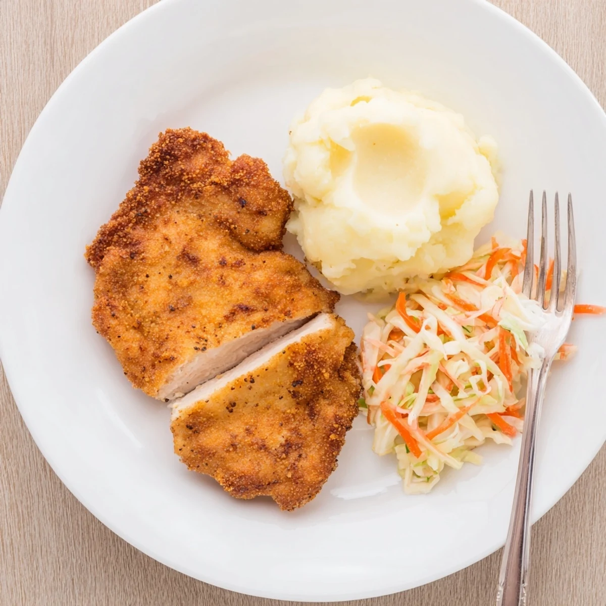 Buttermilk-brined Fried Chicken Breast sliced, juicy interior, served with mashed potatoes