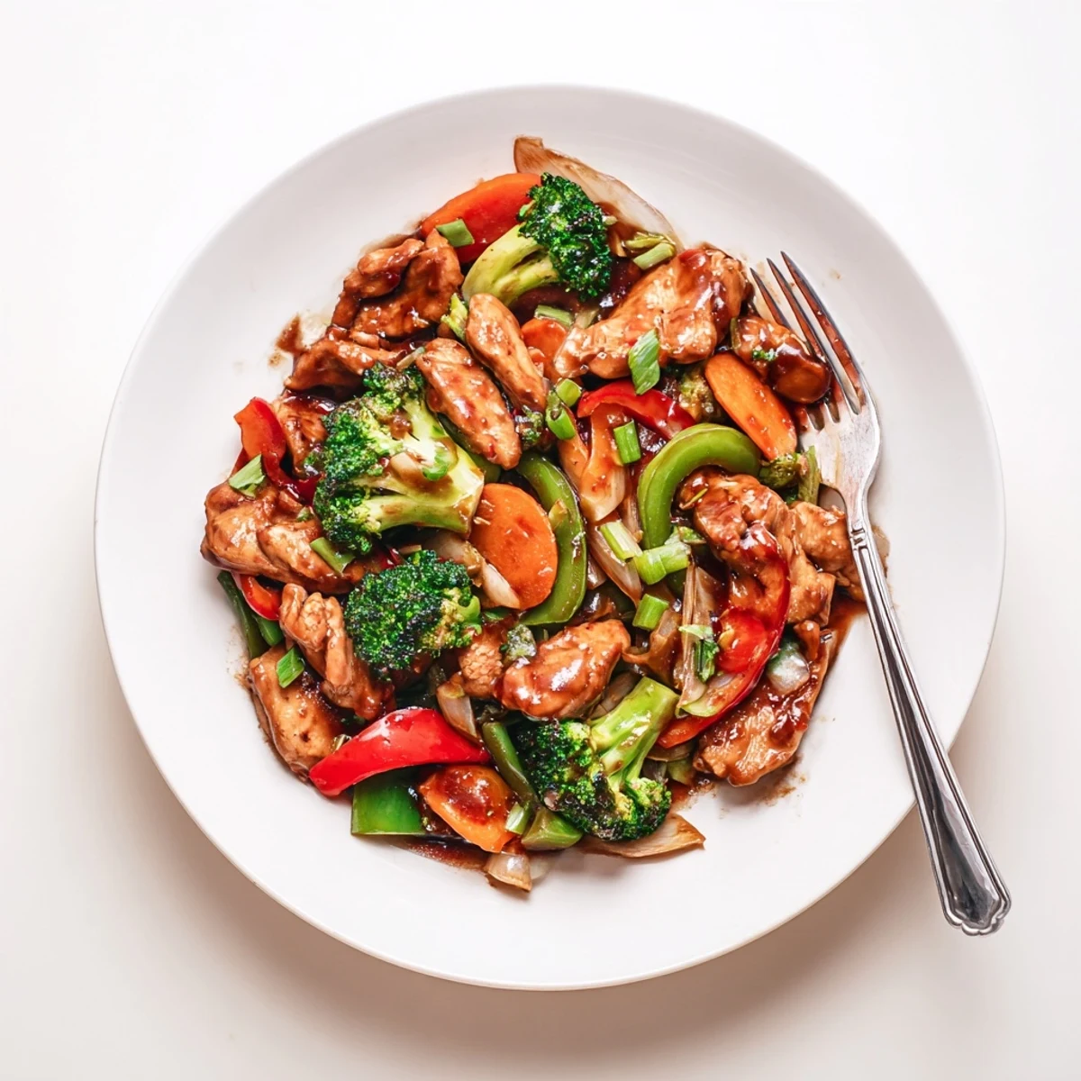 Hunan Chicken glistening in a glossy red sauce over a bed of steamed white rice