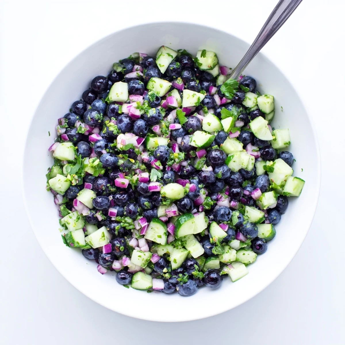 Blueberry cucumber salsa served in a bright bowl with tortilla chips nearby