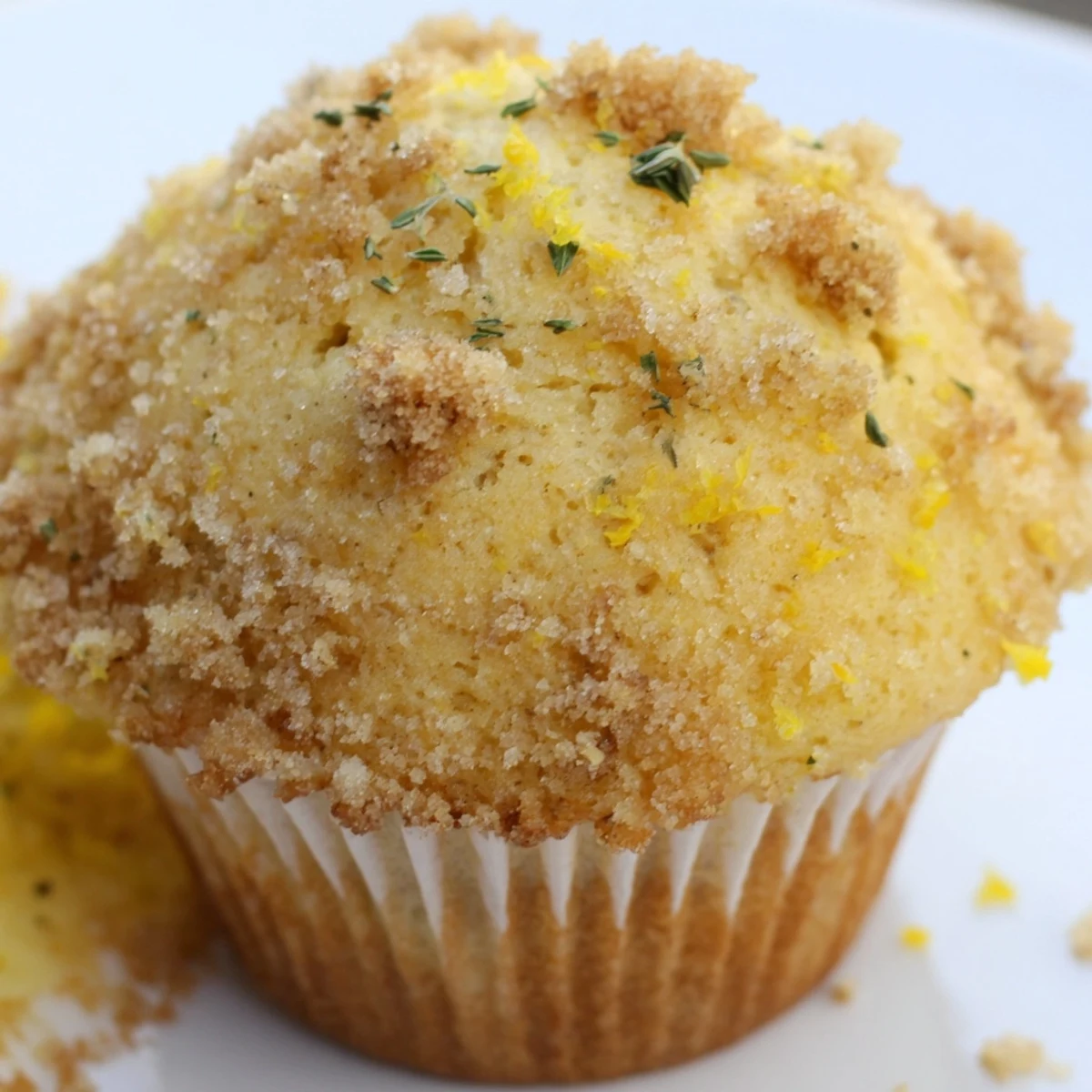 Warm lemon orange honey muffins crowned with herbed thyme crumble served on a ceramic plate