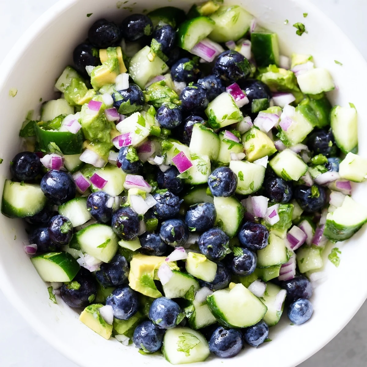 Blueberry cucumber salsa in a bowl with tortilla chips for dipping