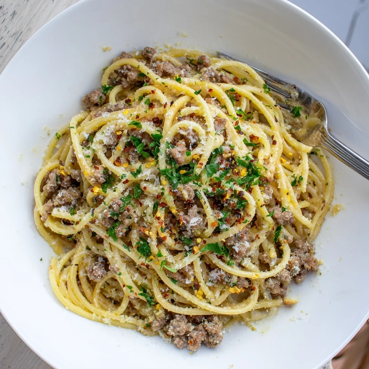 Steaming plate of Garlic Butter Pasta with Ground Beef coated in a silky golden sauce
