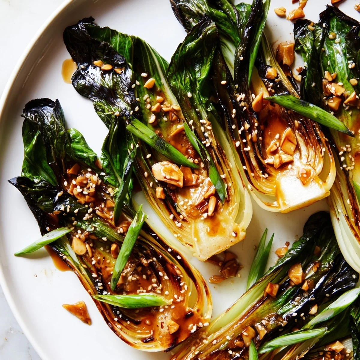 Pan-seared caramelized garlic bok choy glistening with savory soy glaze on a white serving plate