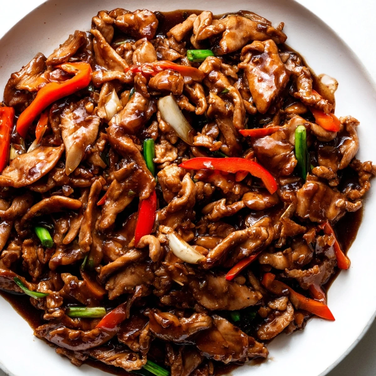 Glossy stir fried Chinese garlic chicken tossed with crisp bell peppers and savory sauce