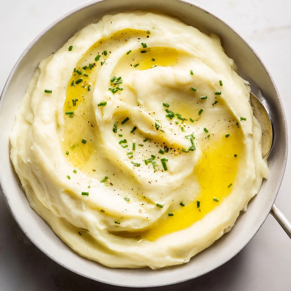 Creamy velvety mashed potatoes piled high and garnished with fresh snipped chives
