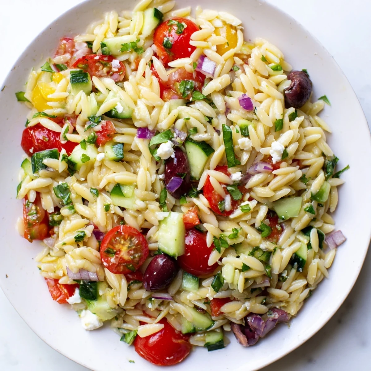 Mediterranean Orzo Pasta Salad tossed in zesty lemon olive oil dressing with fresh herbs and olives