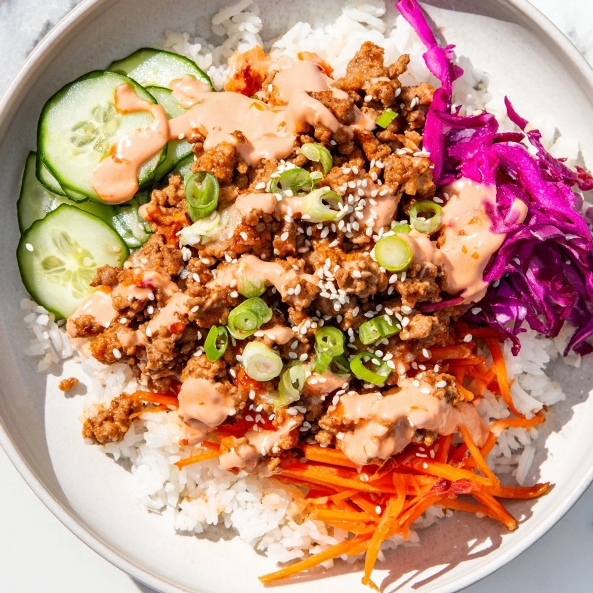Hearty ground turkey rice bowls topped with crisp vegetables and creamy Bang Bang sauce