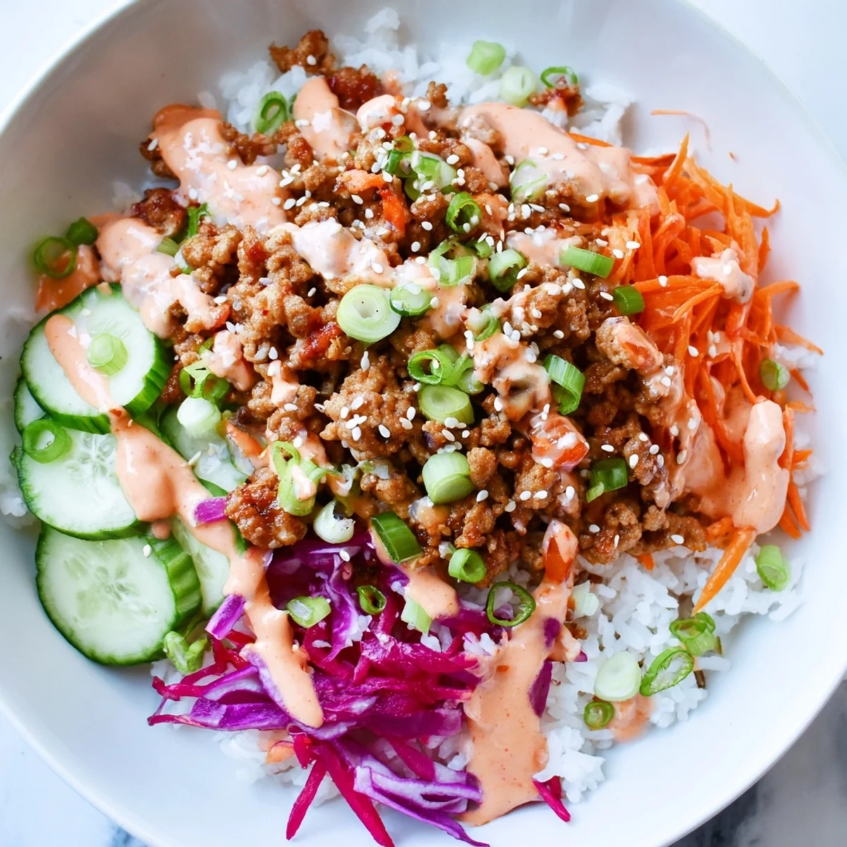 Steaming jasmine rice loaded with seasoned ground turkey and drizzled with spicy Bang Bang sauce