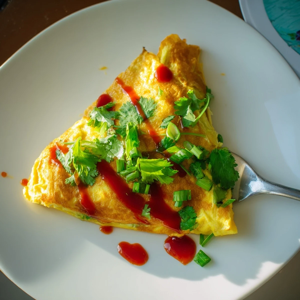Golden Chinese omelette folded over crisp vegetables and fresh scallions on a white plate