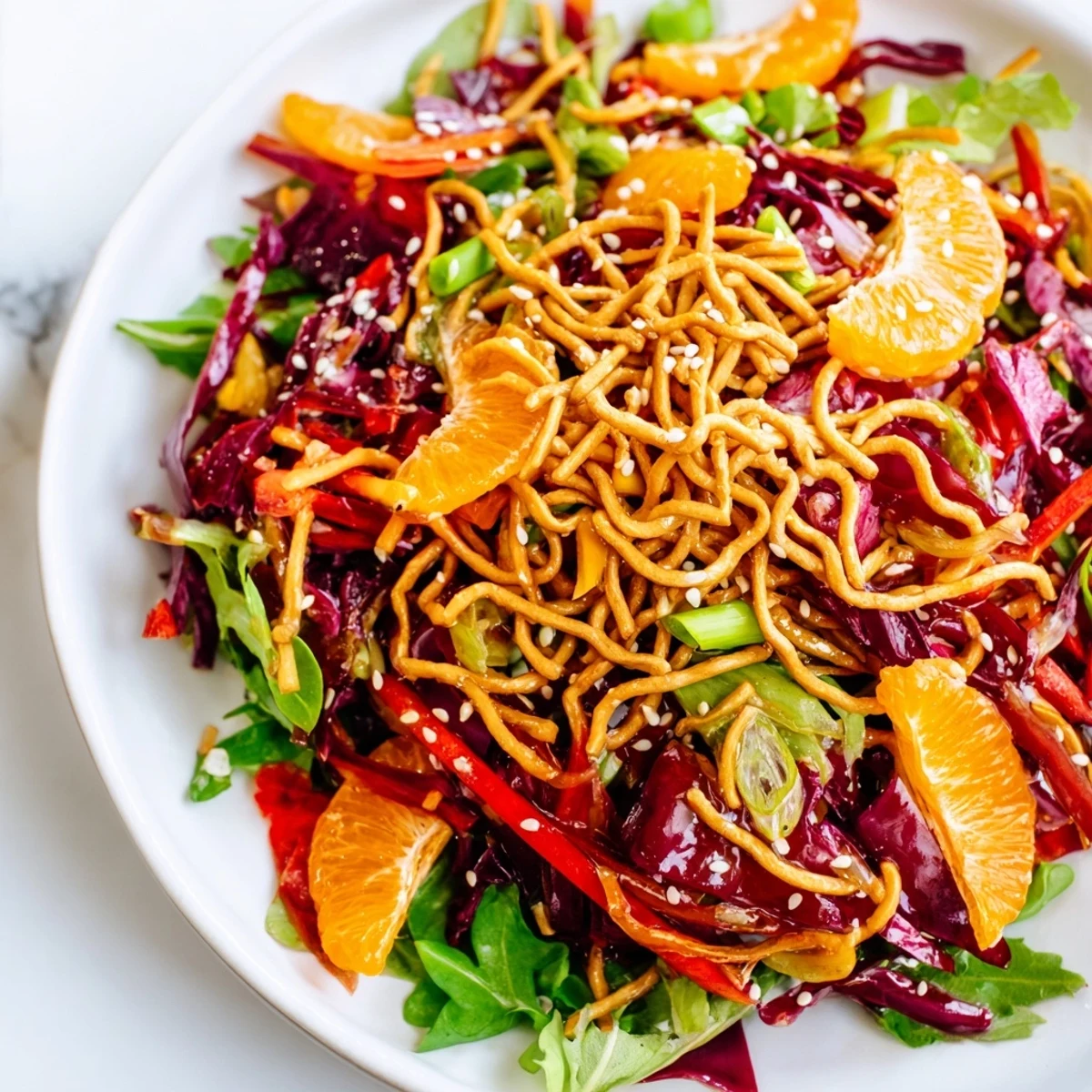 Crisp Mandarin Sesame Crunch Salad topped with golden noodles and sweet orange segments