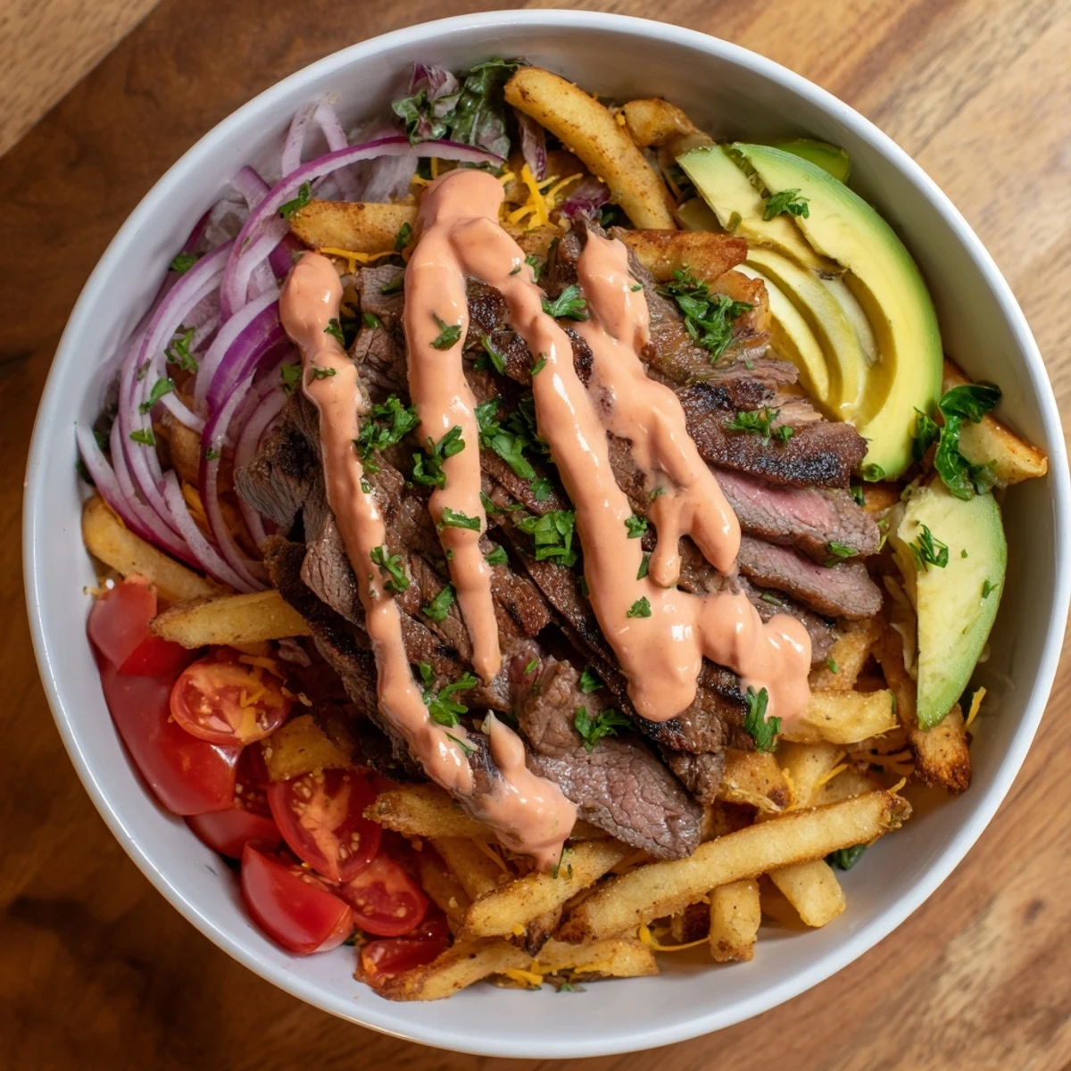 Golden crispy fries topped with tender seared steak strips and fresh vegetables