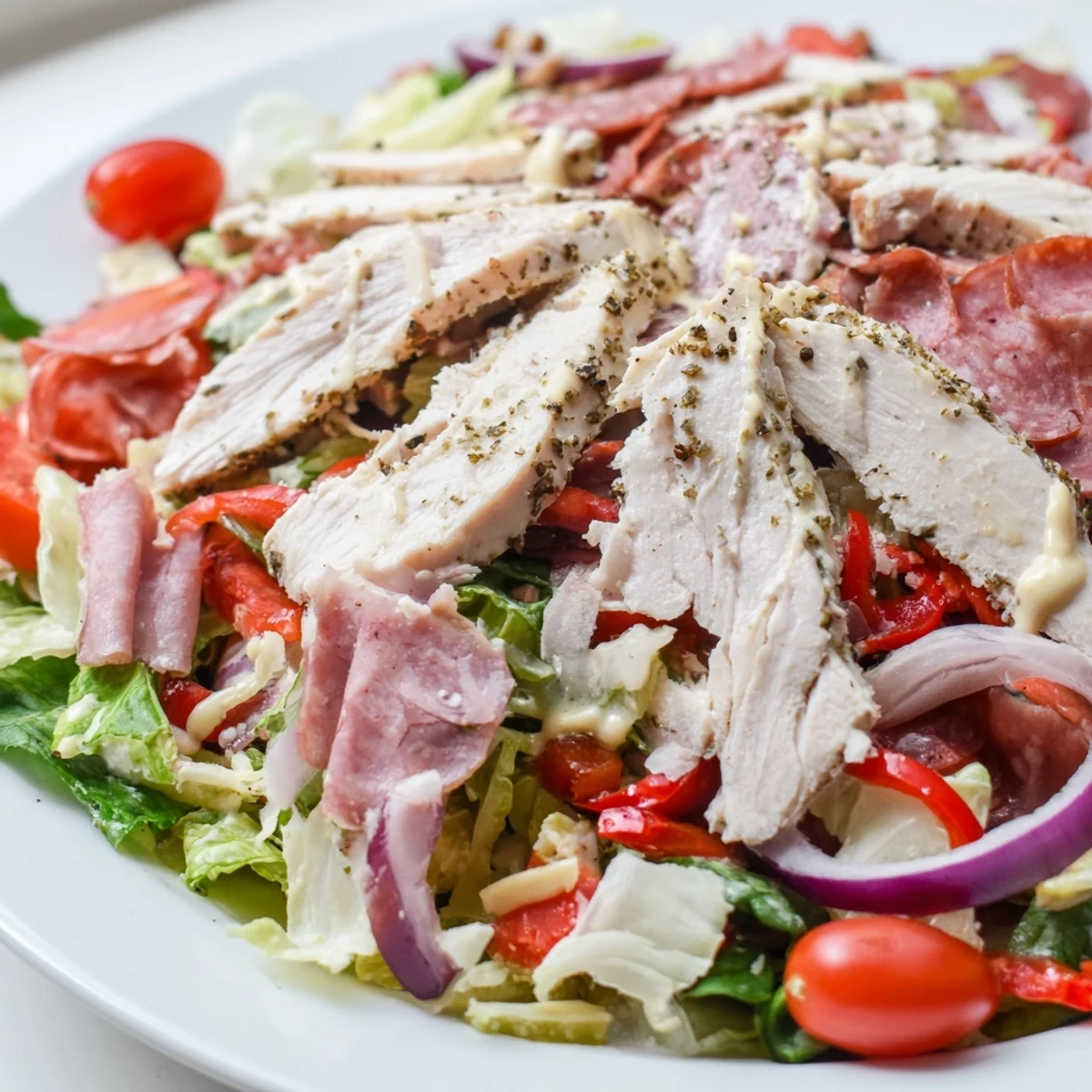 Juicy grilled chicken tops this hearty Italian grinder chicken salad with pepperoncini and tangy dressing