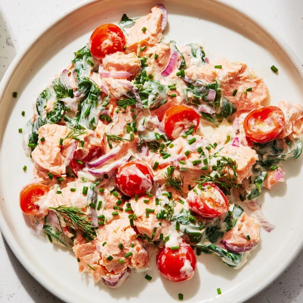 Golden creamy leftover salmon recipe topped with fresh chives and lemon zest